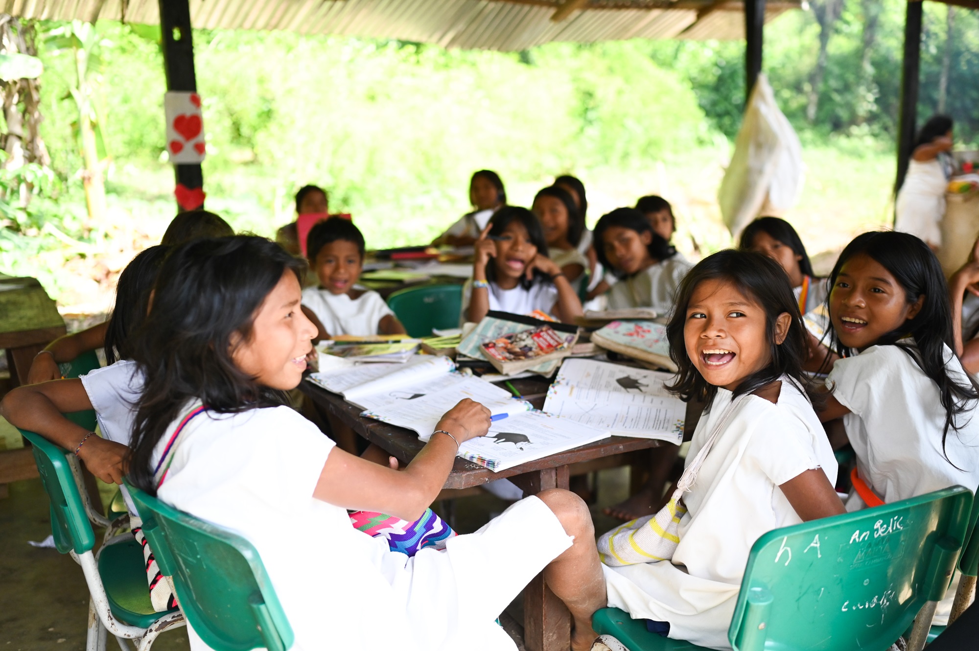 Koululaisia pöydän ääressä ulkona katoksessa