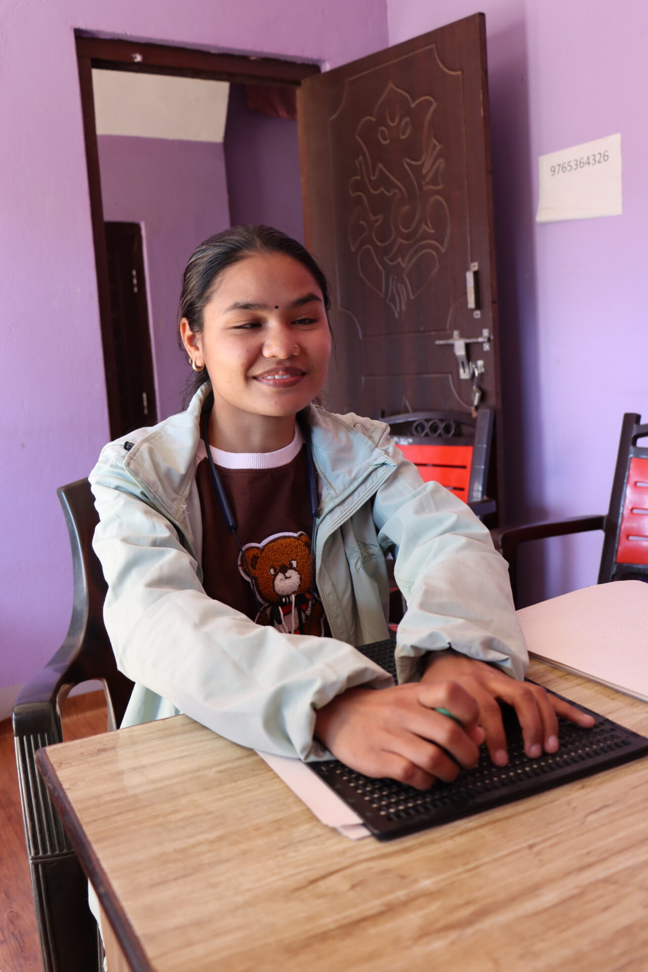 Bishna Kumari Mahataran, a visually impaired sponsored student, writes in Braille using assistive devices provided through the project.