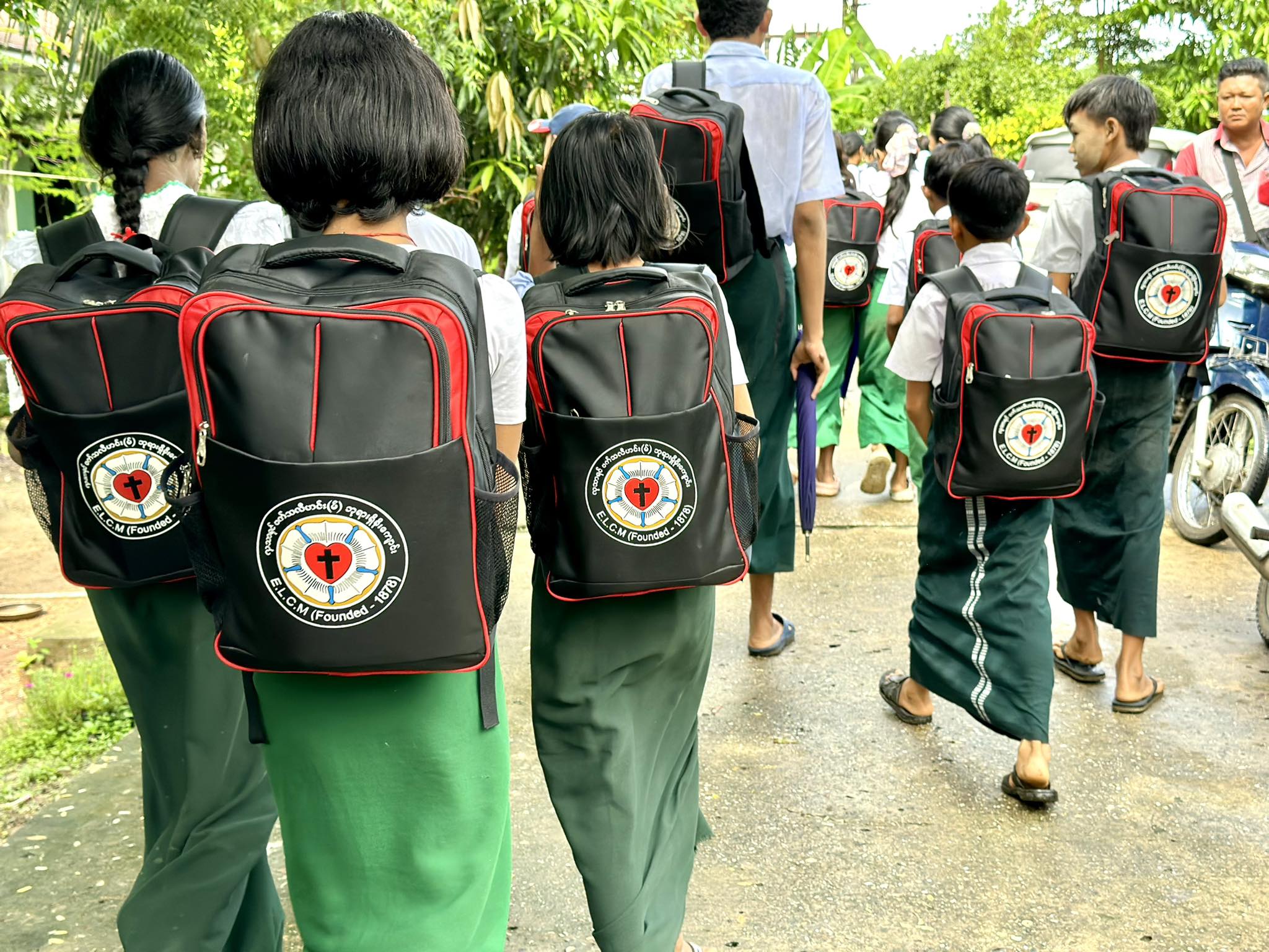 Children walking in line with their backpacks.