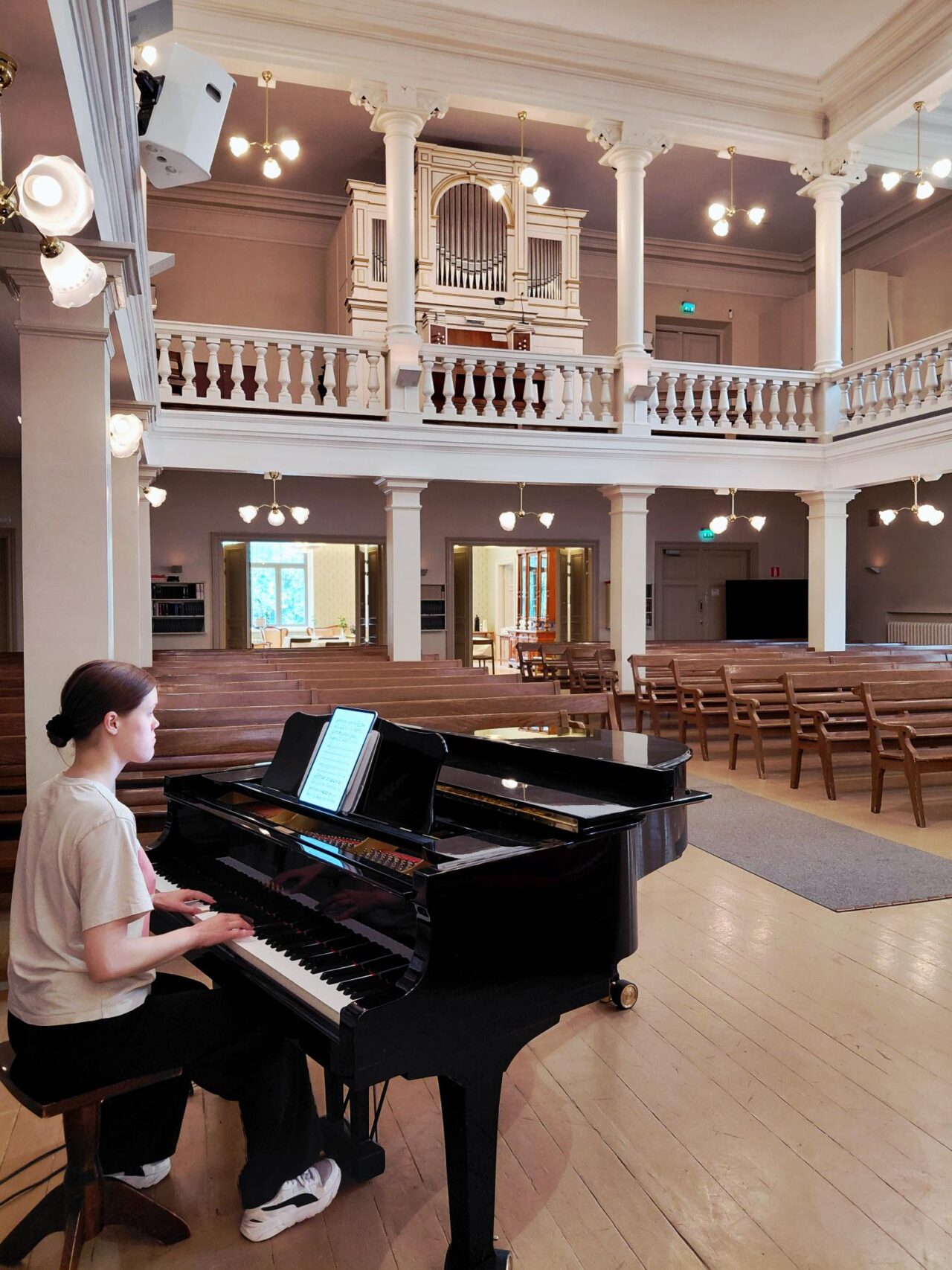 Henkilö soittamassa pianoa Lähetyskirkon kirkkosalissa Tähtitorninkadulla Helsingissä