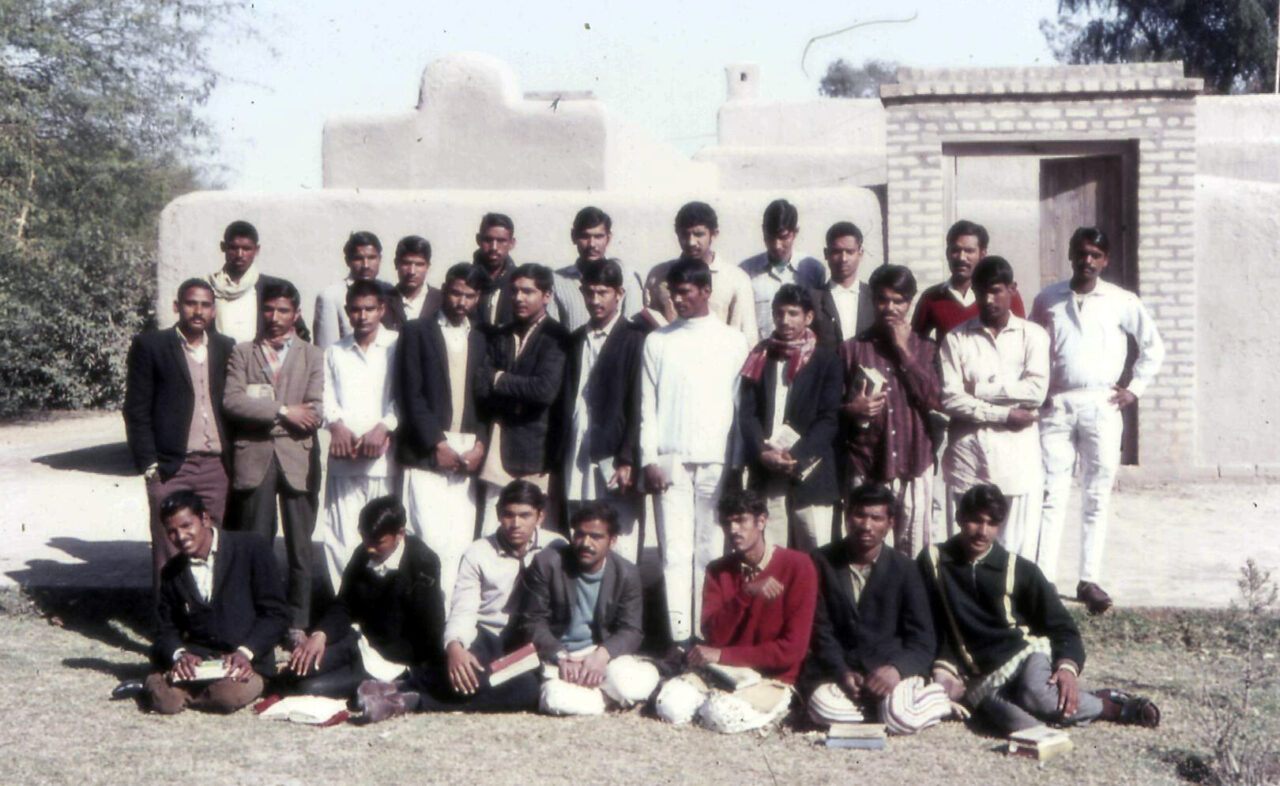 Ryhmäkuva, jossa noin 30 miestä on ulkona. Osa seisoo ja osa istuu.